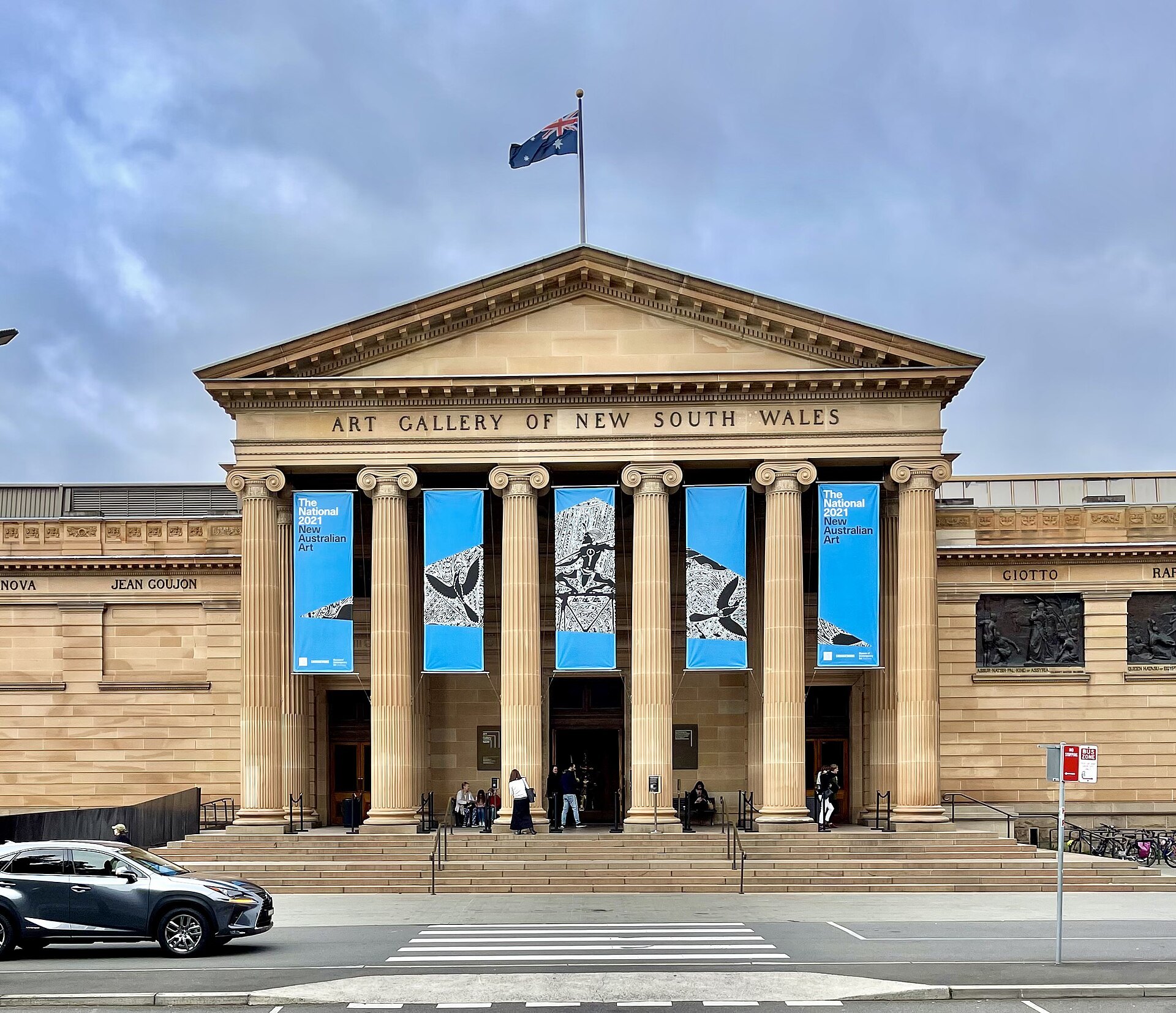 The classical sandstone front of the Art Gallery of New South Wales with banners between its columns