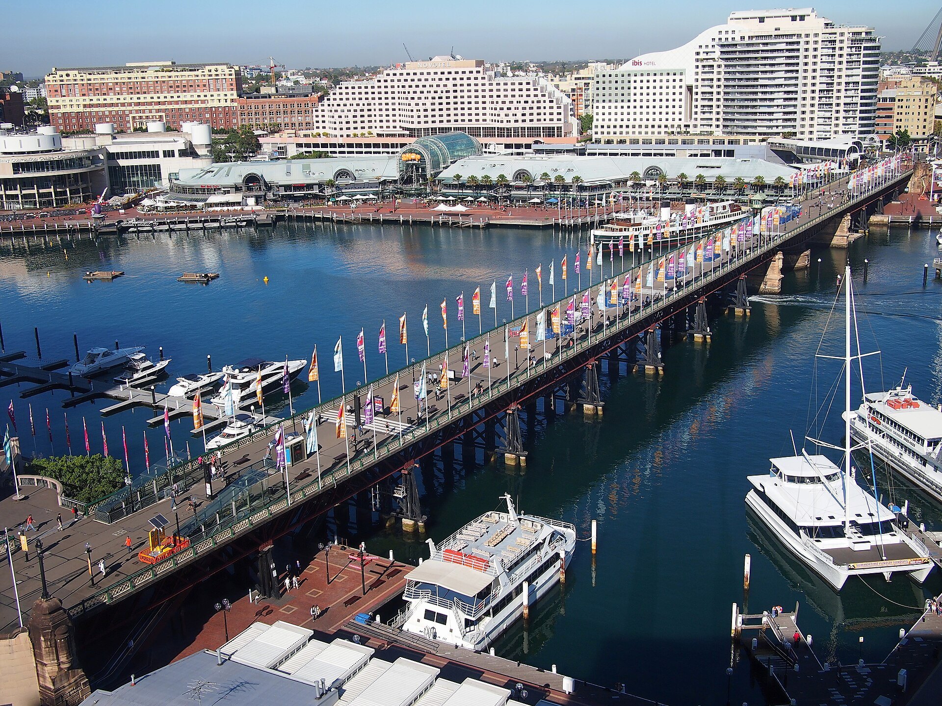 Pyrmont Bridge crossing Darling Harbour from above, boats moored along both sides