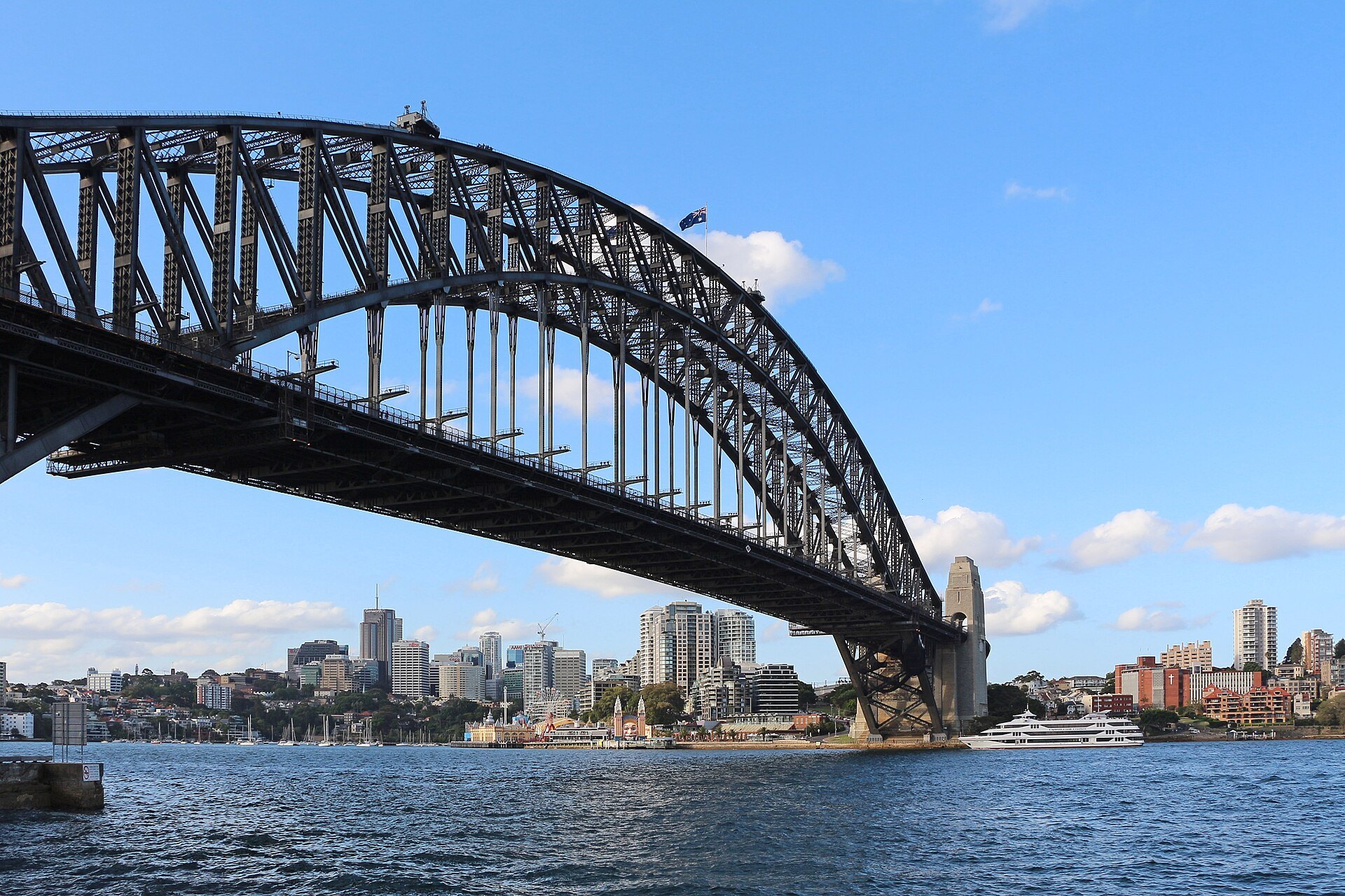 The steel arch of the Harbour Bridge from below, with the north shore behind it