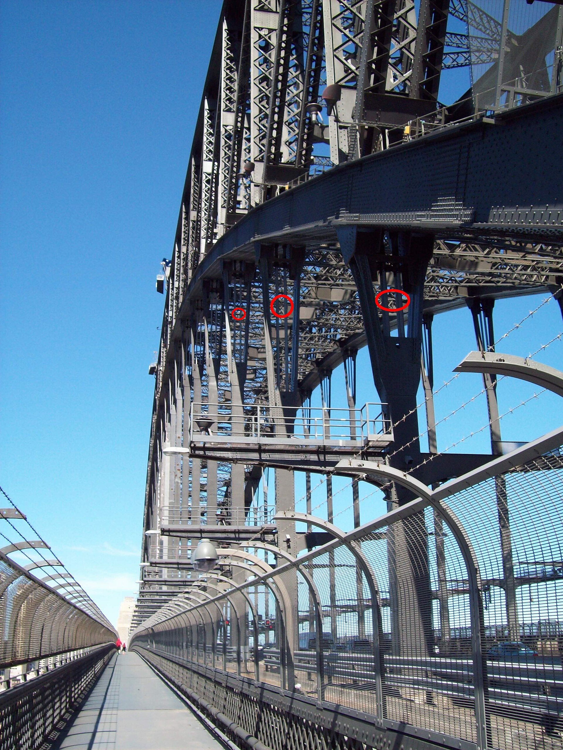 Looking up at the vertical hangers of the Harbour Bridge against the sky