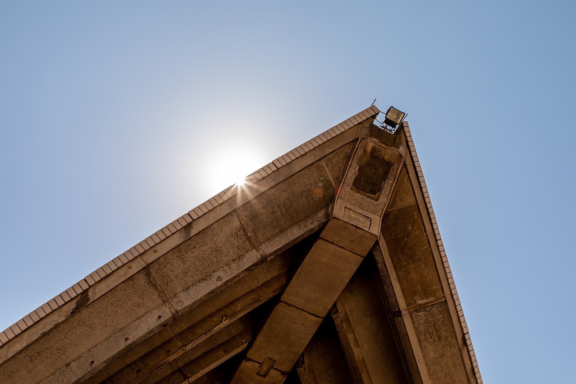 A close view up the edge of one of the Opera House shells against the sun