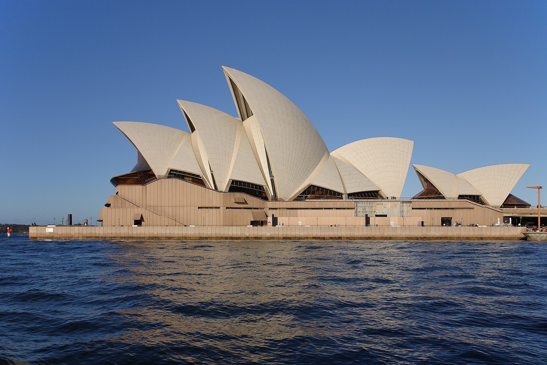 The Opera House seen along the water from the side, its shells overlapping