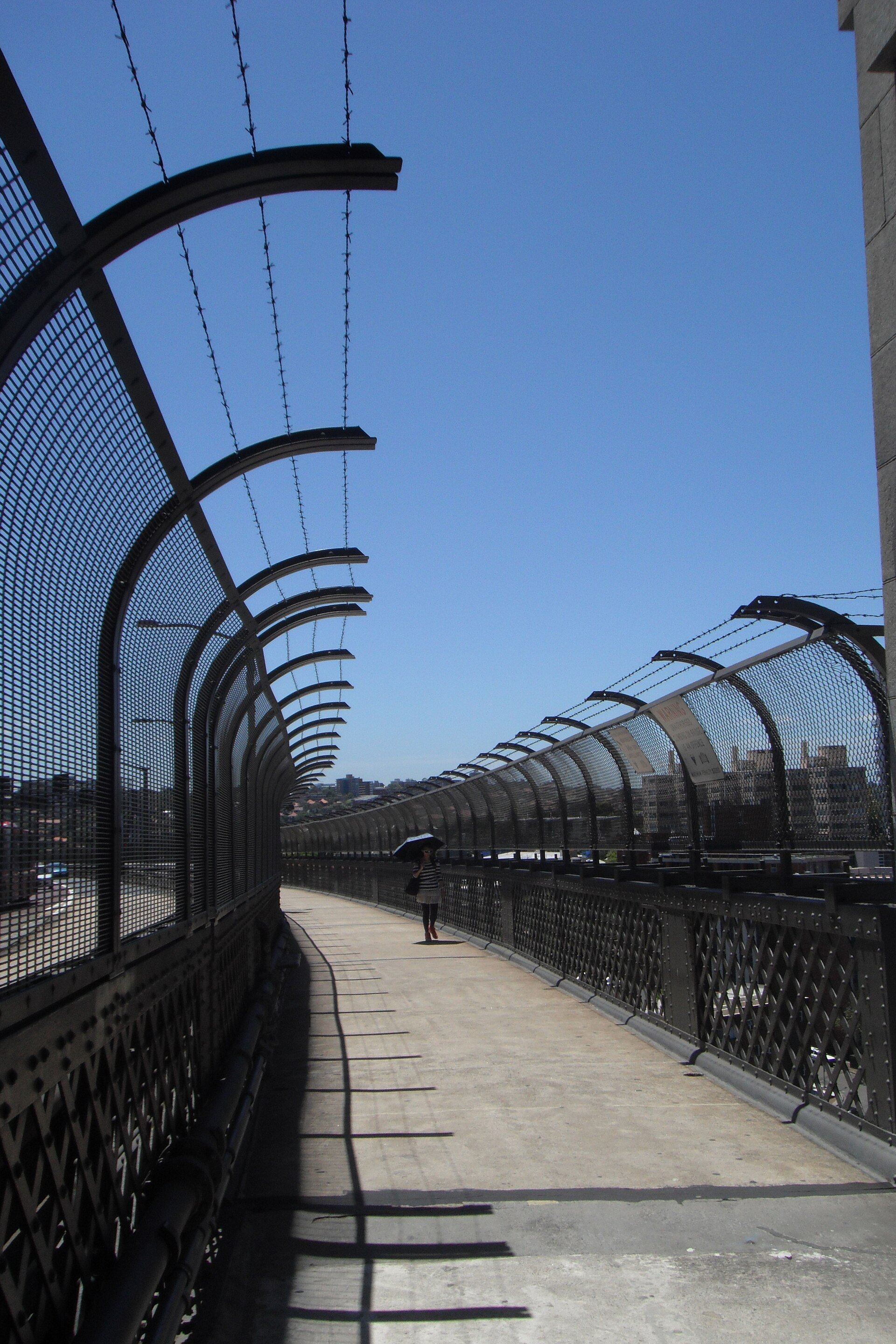 The pedestrian path across the Harbour Bridge, empty, running between the steel and the fence