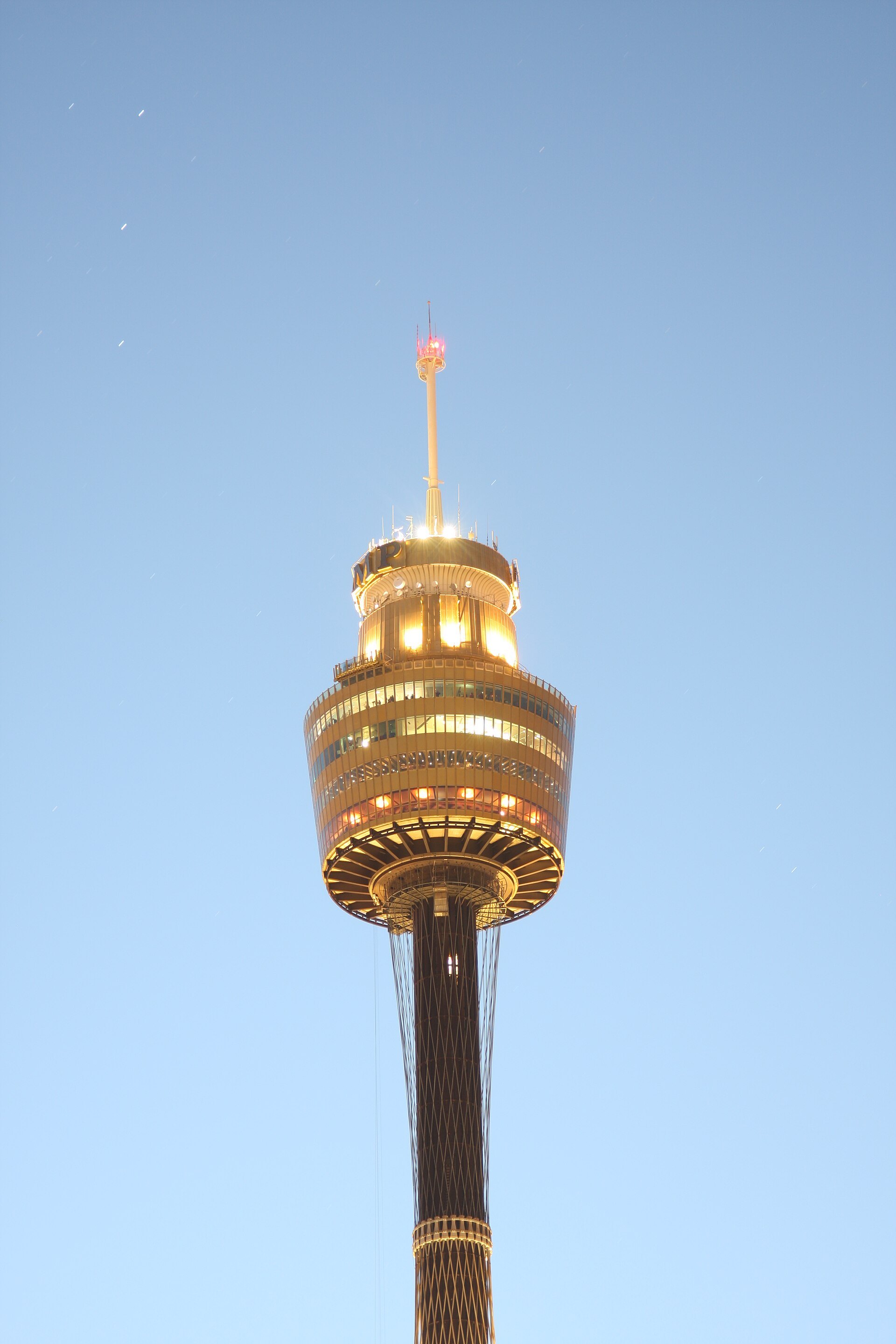 The turret of Sydney Tower close up against a blue sky