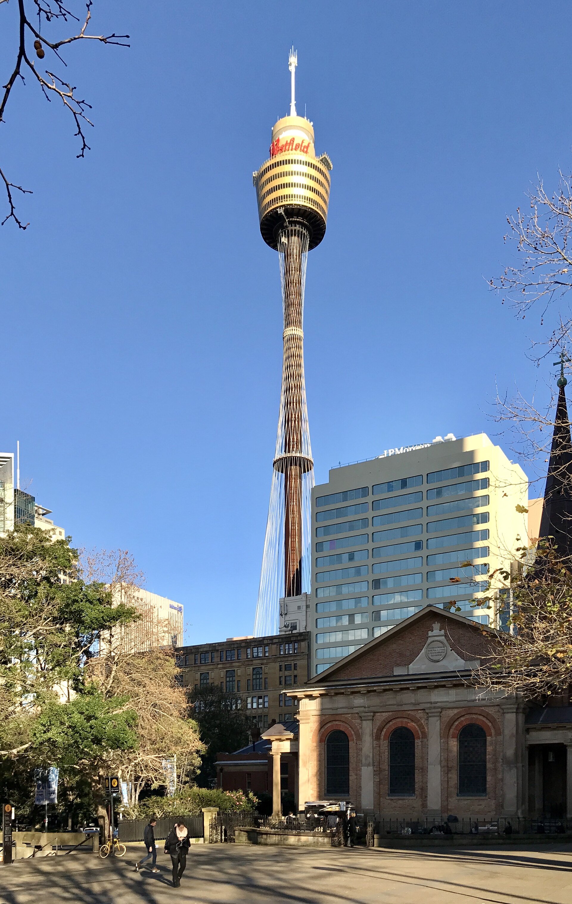 Sydney Tower rising behind a sandstone church